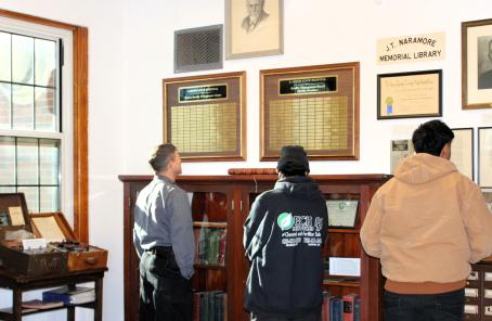 People looking at items on display on the wall and on display shelving